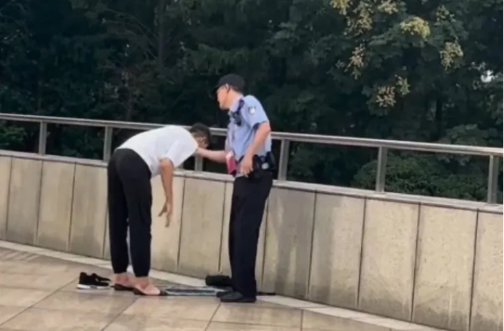 شرطي صيني يحاول منع سائح أوزباكستاني من الصلاة